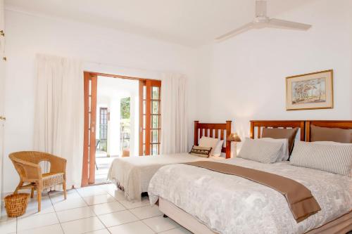a bedroom with two beds and a sliding glass door at Rivendell Bed and Breakfast in Hillcrest