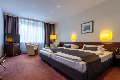 una camera d'albergo con un grande letto e una TV di Trip Inn Hotel Esplanade a Dusseldorf