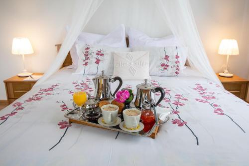 a tray of coffee and tea on a bed at Apartament Na Wierchu in Murzasichle