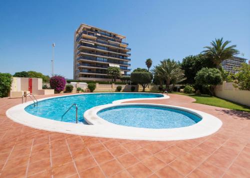 a swimming pool in a resort with a building in the background at Edificio La Reina in Calpe