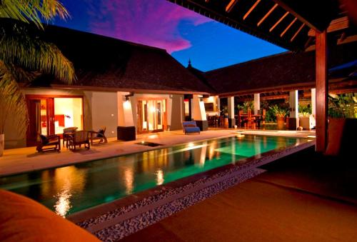 a swimming pool in front of a house at Anyar Estate in Canggu