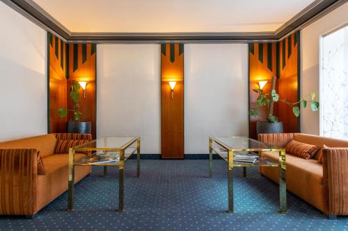 a waiting room with two couches and two tables at Trip Inn Hotel Esplanade, Düsseldorf in Düsseldorf