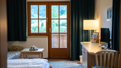 a hotel room with a bed and a window at Der Almhof in Maria Alm am Steinernen Meer