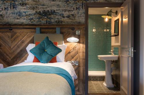 1 dormitorio con 1 cama grande y lavamanos en Dartmoor Halfway Inn, en Newton Abbot