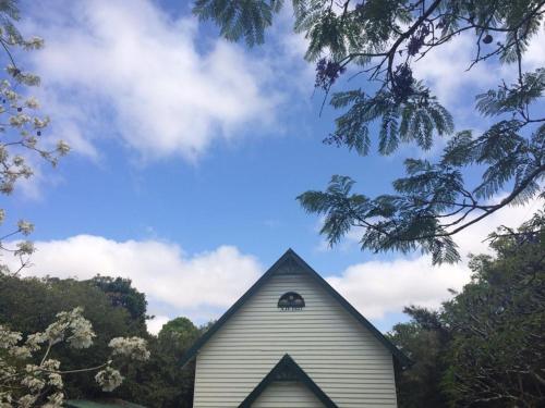 a white church with a window on the top of it at The Church in Yungaburra
