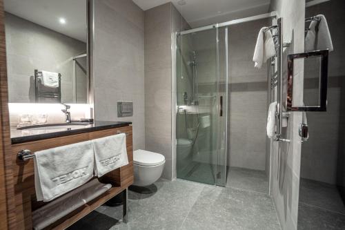 a bathroom with a shower and a toilet and a sink at Hotel Tonanti in Vrnjačka Banja