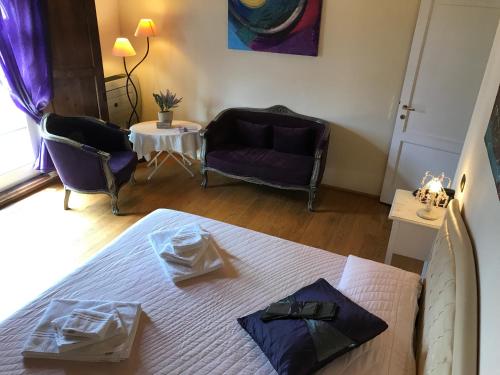 a bedroom with a bed and a couch and a table at L'Albero Di Gamelì in Chiusi