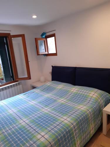 ein Schlafzimmer mit einem Bett mit einer karierten Decke in der Unterkunft Casa Gorne Anzolo in Venedig