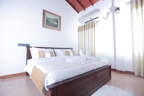 a bedroom with a large bed with white sheets at Grand Casa in Kandy