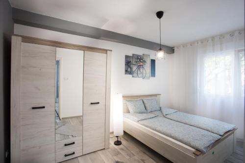 a small bedroom with a bed and a mirror at Apartman Petreš in Sombor