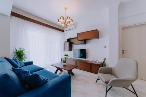 a living room with a blue couch and a table at Kardias Luxury Suites in Iraklitsa