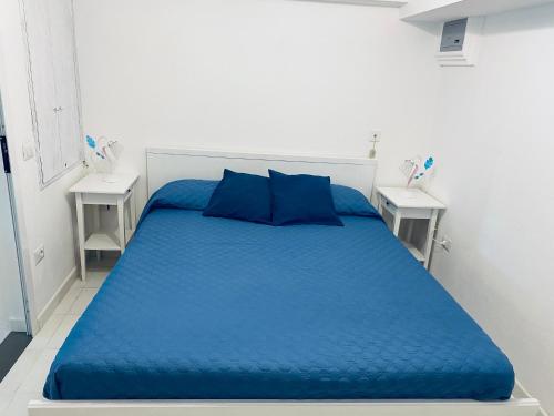 uma cama azul num quarto branco com duas mesas em Casa Amore Positano em Positano