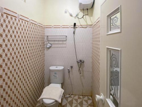 a bathroom with a shower and a toilet in it at RedDoorz Syariah @ Pahlawan Sidoarjo in Sidoarjo