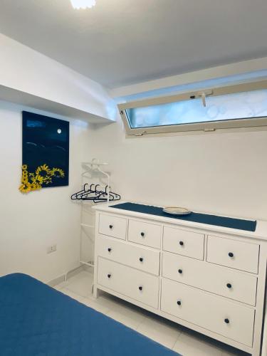 a bedroom with a white dresser and a window at Casa Amore Positano in Positano