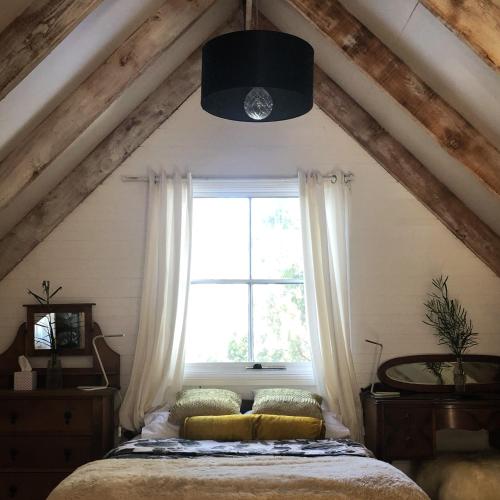 a bedroom with a bed and a window at Cottage At 31 in Bundanoon
