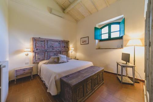 a bedroom with a large bed and a window at Country Relais La Mortella in Porto Ercole