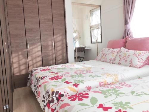 a bedroom with a bed with a floral bedspread at TerraceRin YN23 in Tomigusuku