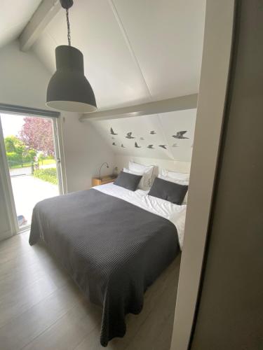a bedroom with a bed with birds on the wall at Aan de Vecht in Nederhorst den Berg