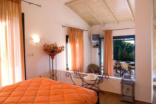 a bedroom with a bed and a table and a balcony at VILLA TIMOKLIA in Tsoukalades