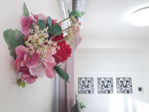 a bouquet of flowers hanging on a wall at TerraceRin YN23 in Tomigusuku