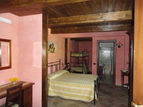 a bedroom with a bed in a room with pink walls at Green House in Morano Calabro
