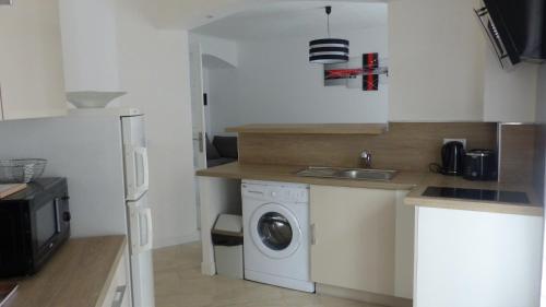 une cuisine avec une machine à laver et un évier dans l'établissement Residence Mistral, à Cannes