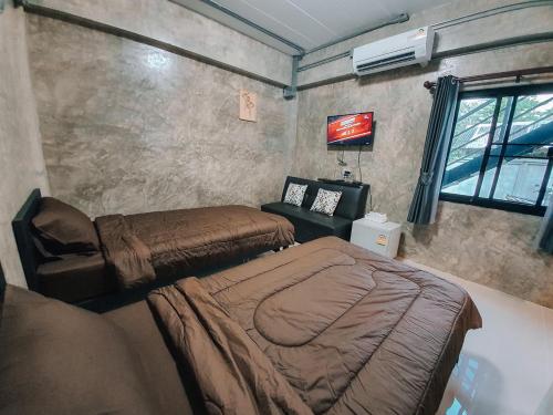a bedroom with two beds and a couch and a tv at Amante Baristro Hotel & Cafe' @Pua in Nan