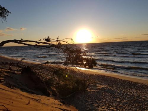 a sunset on the beach with the sun setting at Porta Sunrise in Dziwnówek