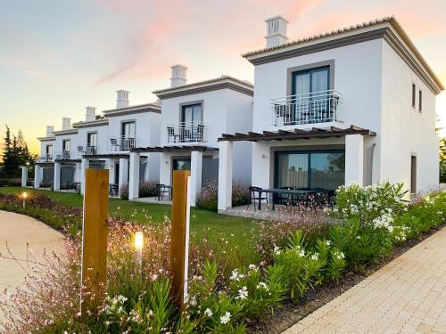 a white house with a garden in front of it at Quinta do Algarvio Village in Carvoeiro