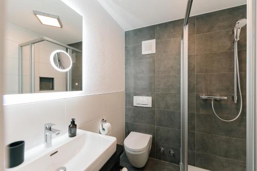 a bathroom with a shower and a toilet and a sink at Moderne 3 Zi.-FeWo Scandi Style 70 qm Nähe Freiburg in Simonswald