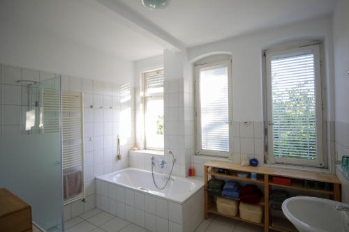 een badkamer met een bad, een douche en een wastafel bij VILLA14 in Offenburg