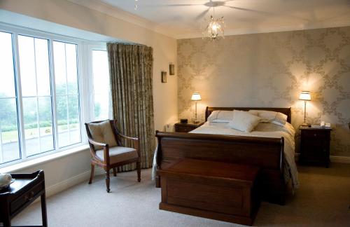 1 dormitorio con 1 cama, 1 silla y 1 ventana en Rivermount House, en Kinsale