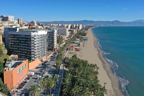 a view of a beach with palm trees and buildings at Melia Costa del Sol in Torremolinos