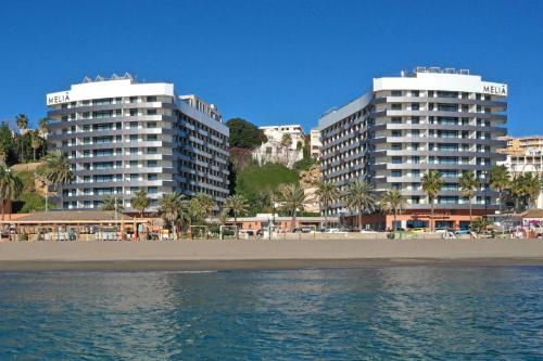 two tall buildings on a beach next to the ocean at Melia Costa del Sol in Torremolinos