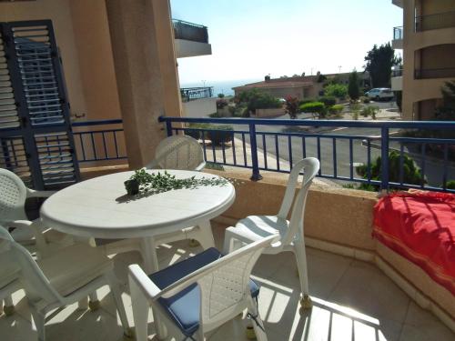 a white table and chairs on a balcony with a view at Kings Palace Indigo 109 in Paphos