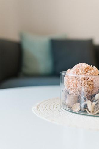 a glass vase filled with flowers and shells on a table at Moderne 3 Zi.-FeWo Scandi Style 70 qm Nähe Freiburg in Simonswald