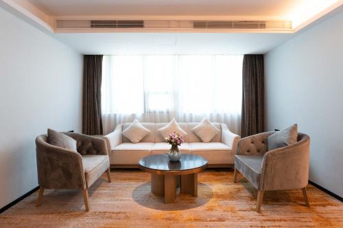 a living room with a couch and chairs and a table at Zhong Tai Lai Hotel Shenzhen in Shenzhen