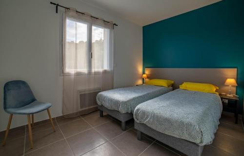 a bedroom with two beds and a chair and a window at Gite LES BOUCHES ROUGES avec piscine privée in Vesseaux