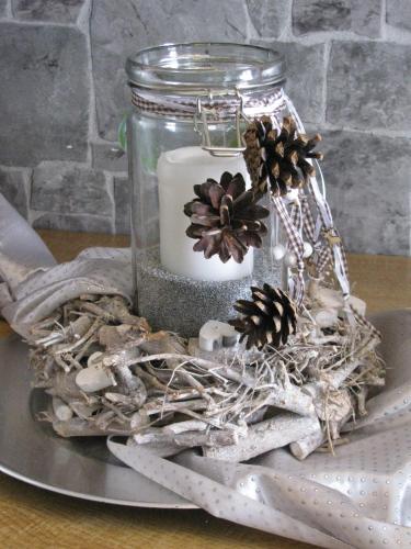 a mason jar with a candle and pinecones at Hotel Kilian in Braunlage