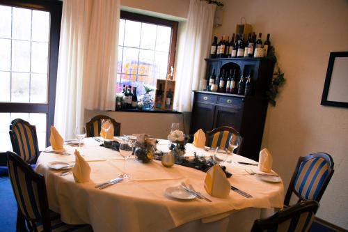 a dining room table with a white table cloth and chairs at Landhotel Laarmann in Lennestadt