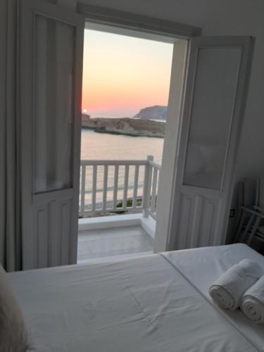 a bedroom with a bed and a view of the ocean at en lefko in Lefkos Karpathou