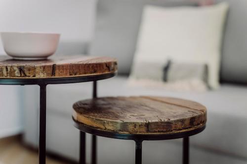 a couple of wooden tables with a bowl on top at Nádas Center Home Badacsony in Badacsonytomaj