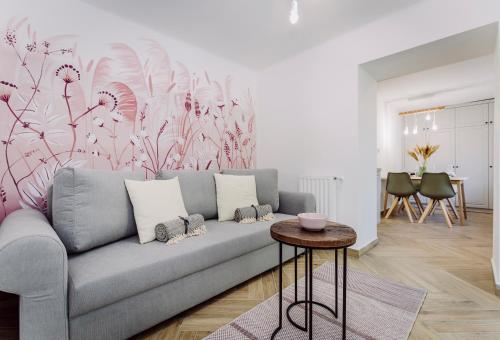 a living room with a couch and a pink flower mural at Nádas Center Home Badacsony in Badacsonytomaj