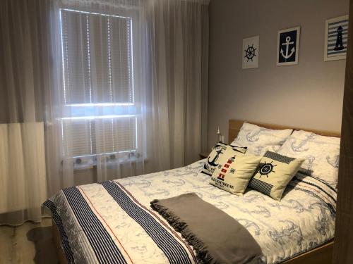 sypialnia z łóżkiem z poduszkami i oknem w obiekcie Bel Mare Międzyzdroje w mieście Międzyzdroje