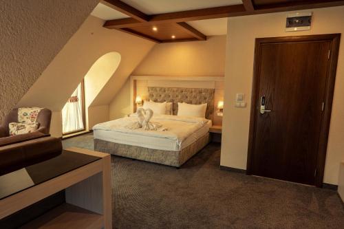a bedroom with a bed and a chair and a door at Boutique hotel Provence Бутик хотел Прованс in Petrich