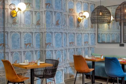 a restaurant with two tables and chairs and a blue wall at Lyric Hotel Paris Opera in Paris