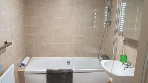 a bathroom with a bath tub and a sink at Ynys Lawd, Holyhead Marina in Holyhead
