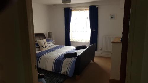 a bedroom with a bed and a window at Ynys Lawd, Holyhead Marina in Holyhead