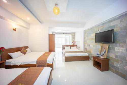 a hotel room with two beds and a flat screen tv at My Kim Guest House in Da Lat