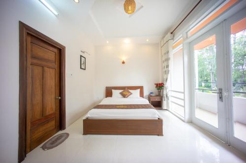 a bedroom with a bed and a large window at My Kim Guest House in Da Lat